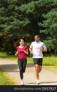 Smiling young couple running in park