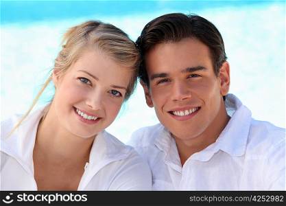 Smiling young couple sitting in the sunshine