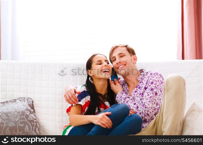 Smiling young couple speaking phone together&#xA;