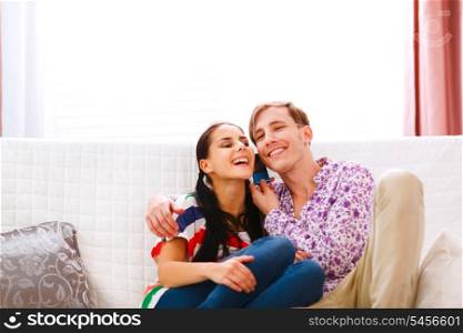 Smiling young couple speaking phone together&#xA;