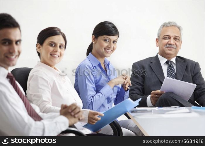 Smiling young executives with mature businesspeople