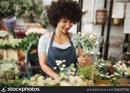 smiling young female florist arranging flowers shop