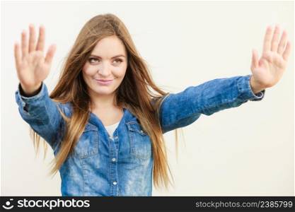 Smiling young girl showing gesture. Woman holding her arms up front. Leisure lifestyle fashion concept. . Smiling young girl showing gesture.