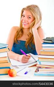 Smiling young girl sitting at table with lots of books&#xA;