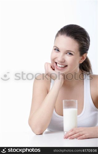 Smiling young girl with a glass of milk on a white background