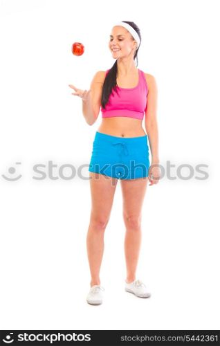 Smiling young healthy girl in sportswear throwing apple up isolated on white&#xA;