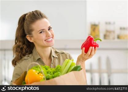 Smiling young housewife examines purchases after shopping in kitchen