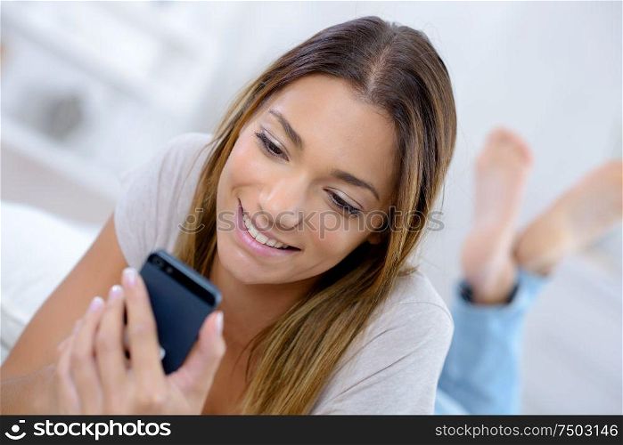 Smiling young lady looking at cellphone
