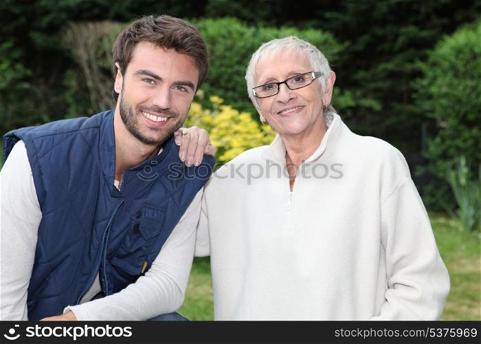 smiling young man and older woman in garden