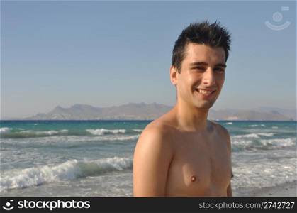 smiling young man at Kos beach in Greece (blue sky)