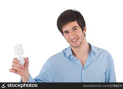 Smiling young man holding energy saving light bulb on white background