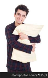 smiling young man in pajamas holding pillow isolated on white background