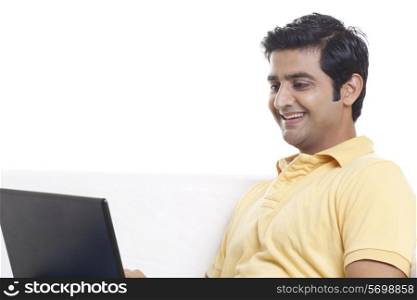 Smiling young man looking at laptop screen