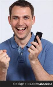 Smiling young man on his mobile phone against a white background