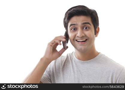 Smiling young man using mobile phone over white background