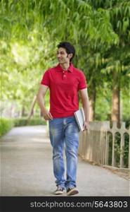 Smiling young man walking in park