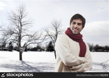 Smiling young man with bare trees in the background