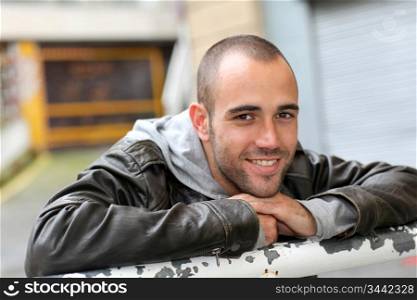 Smiling young man with leather jacket in town