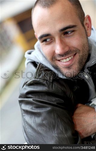Smiling young man with leather jacket in town