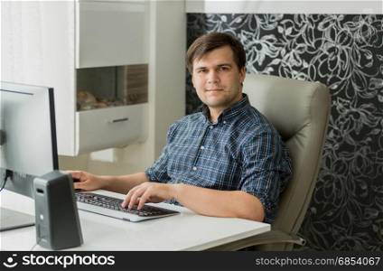 Smiling young man working at home office