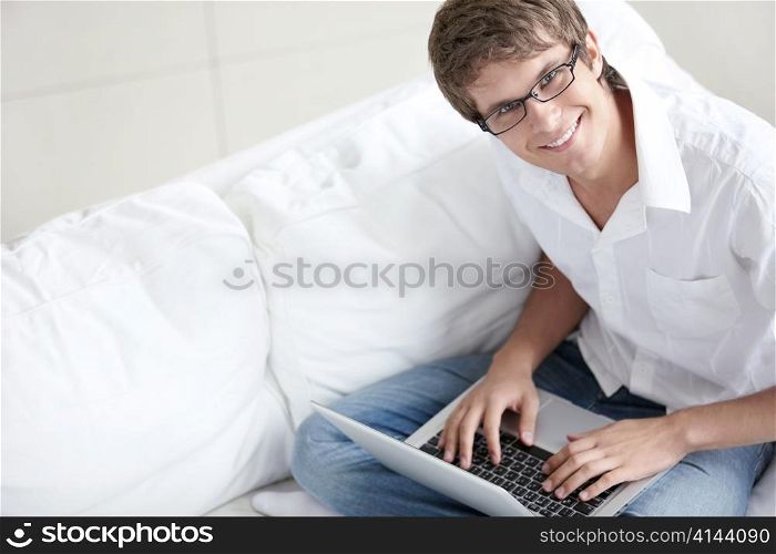 Smiling young man working with laptop