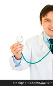 Smiling young medical doctor holding up stethoscope isolated on white. Close-up.&#xA;