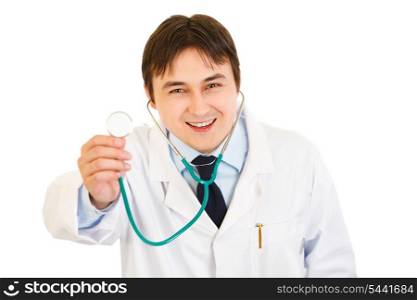 Smiling young medical doctor holding up stethoscope isolated on white&#xA;