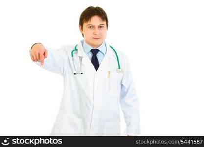 Smiling young medical doctor pointing finger down isolated on white&#xA;