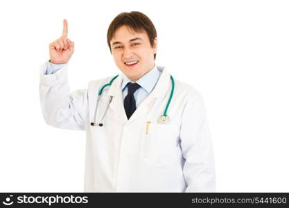 Smiling young medical doctor pointing finger up isolated on white&#xA;