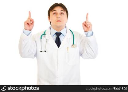 Smiling young medical doctor pointing fingers up isolated on white&#xA;