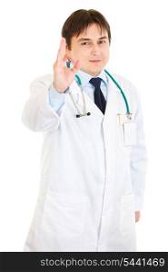 Smiling young medical doctor showing ok gesture isolated on white&#xA;