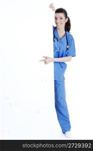 Smiling young nurse pointing blank board over isolated white background