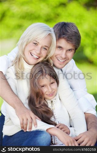 Smiling young parents with daughter outdoors