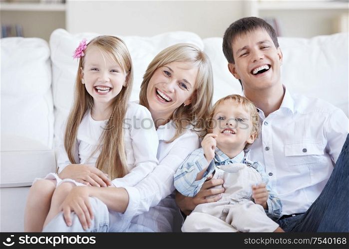 Smiling young parents with two children at home