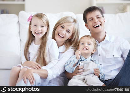 Smiling young parents with two children at home