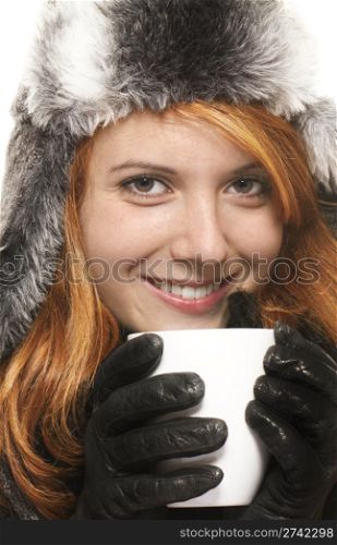 smiling young redhead woman in winter dress holding coffee cup . smiling young redhead woman in winter dress holding coffee cup on white background