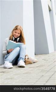 Smiling young study woman read book outdoor high-school building