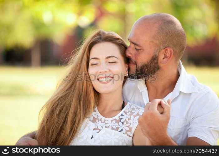 Smiling Young Woman and Young Man are Happy Together - they are Smiling and Embracing in Nature at the Bright Sunny Day