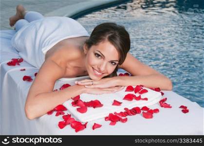 Smiling young woman at spa with pool in the background