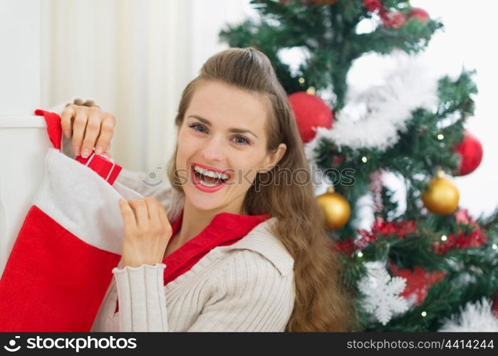 Smiling young woman checking Christmas socks