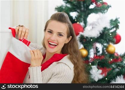 Smiling young woman checking Christmas socks