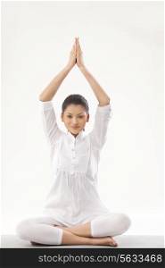 Smiling young woman doing yoga over white background