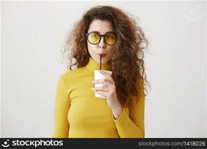 Smiling young woman drinking smoothie juice. Isolated portrait. Smiling young woman drinking smoothie juice. Isolated portrait.