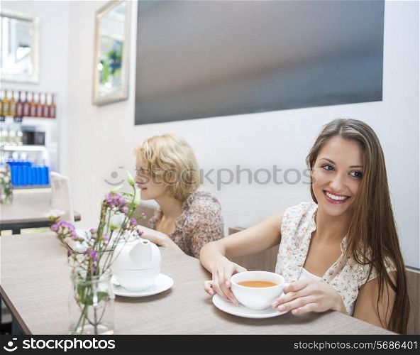 Smiling young woman having coffee in cafe