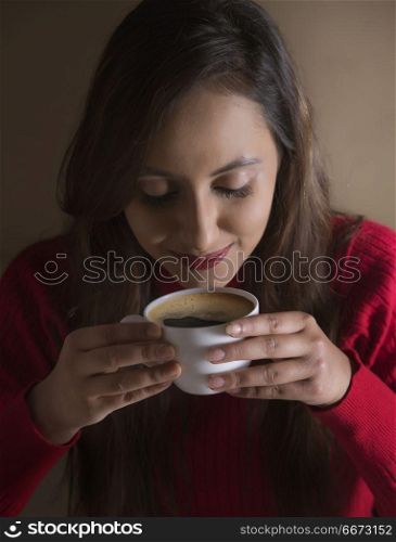 Smiling young woman having cup of coffee