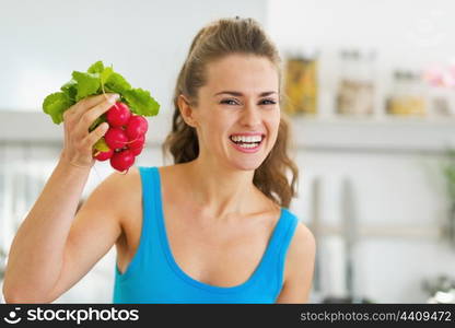 Smiling young woman holding bunch of radishes