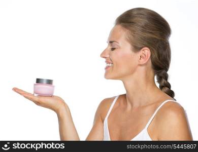 Smiling young woman holding cream bottle