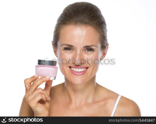 Smiling young woman holding cream bottle
