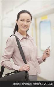 Smiling young woman holding mobile phone