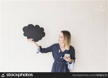 smiling young woman holding mobile phone cloud made cardboard